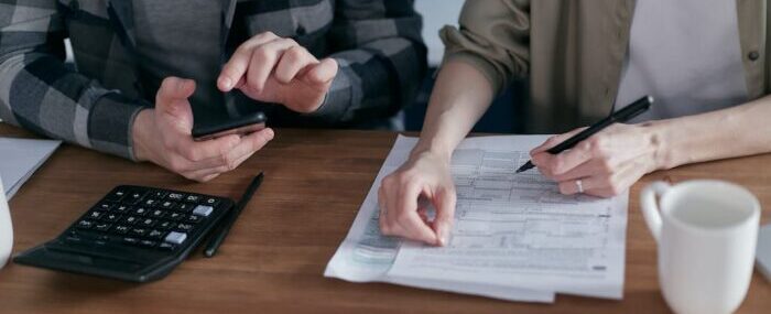 Two People Doing Paperwork and Computing Taxes